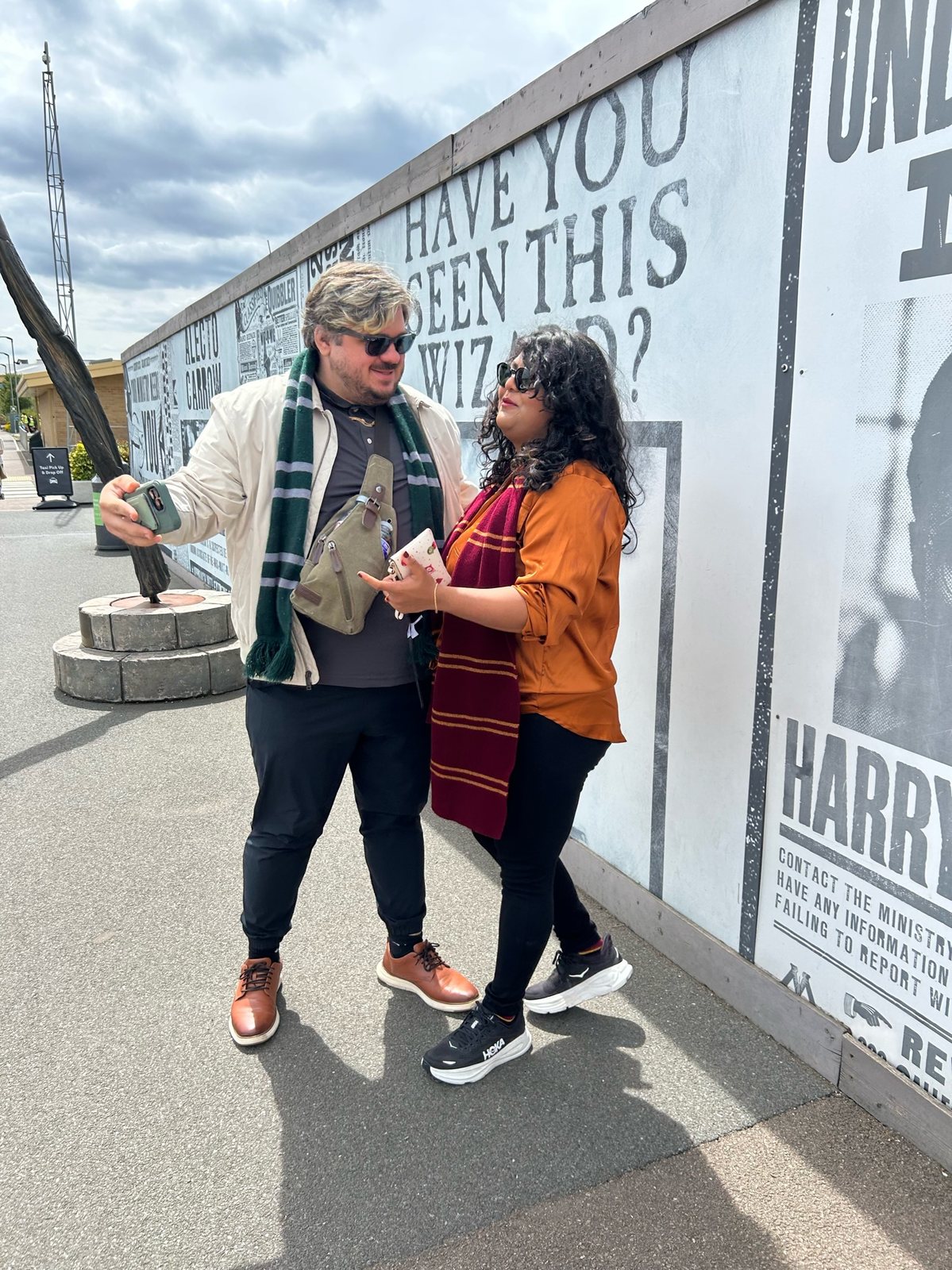 Monica and Austin in Gryffindor and Slytherin scarves outside the studio tour