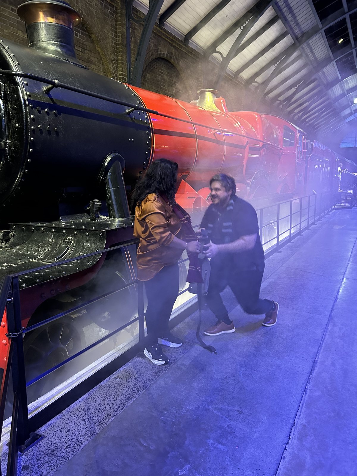 Austin on one knee proposing in front of the Hogwarts Express